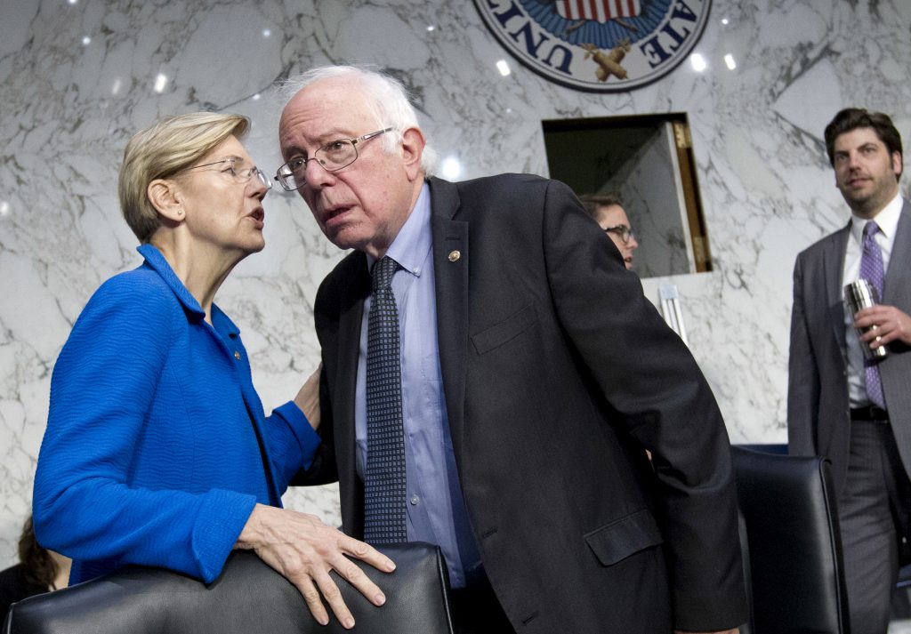 Bernie Sanders et al. standing next to a man in a suit and tie