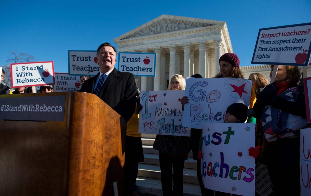 A group of people standing in front of a sign